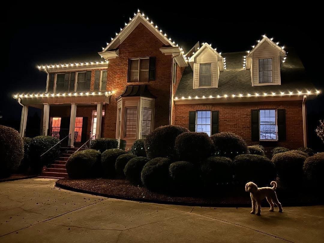 Warm white Christmas C9 lights installed on a two-story brick home