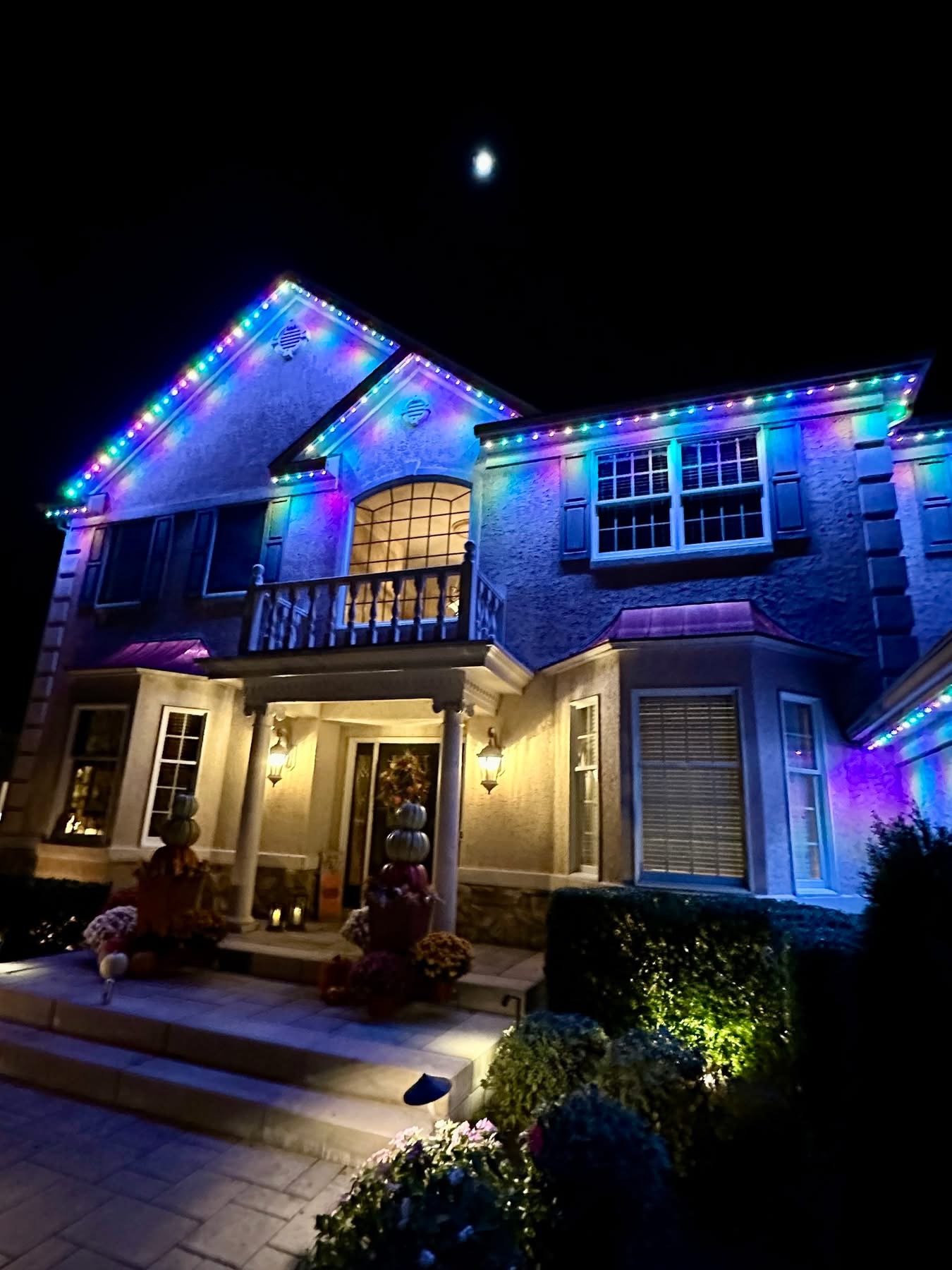Color-changing permanent lighting installed on a home at night